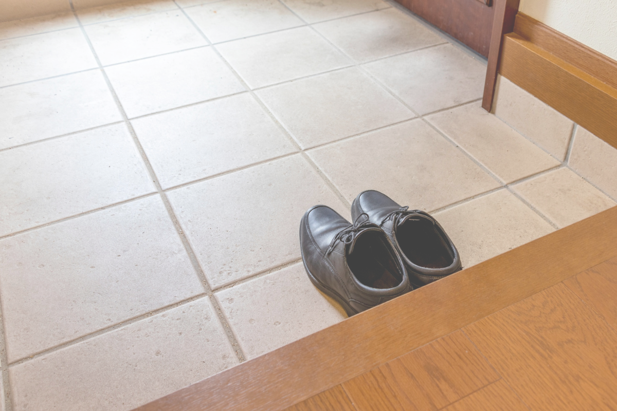 A Japanese home entrance with shoes left on the lower floor by the doorway