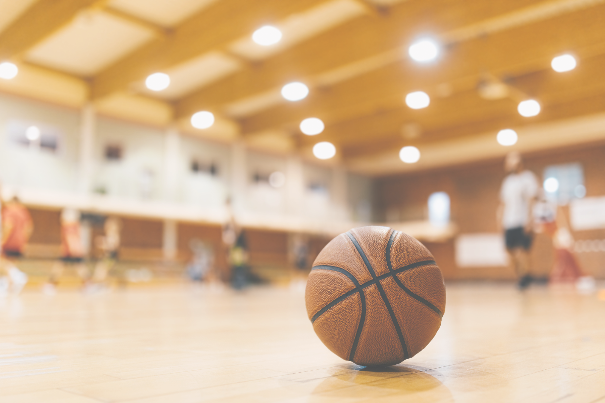 Students practicing basketball together inside a school gym