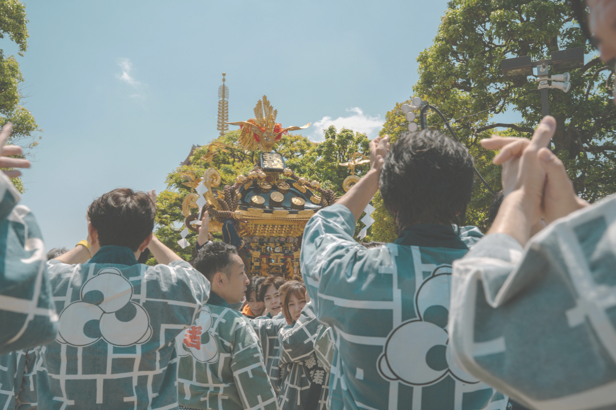 People wearing happi coats carrying a mikoshi at a local festival in Japan