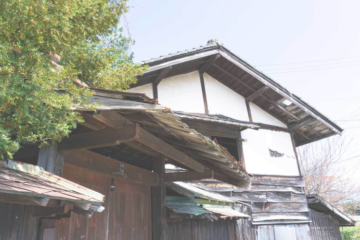An older Japanese house with a tiled roof and weathered wooden exterior