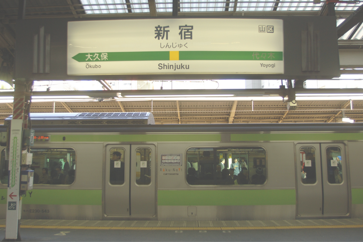 Train at a platform with a Shinjuku Station sign in Tokyo