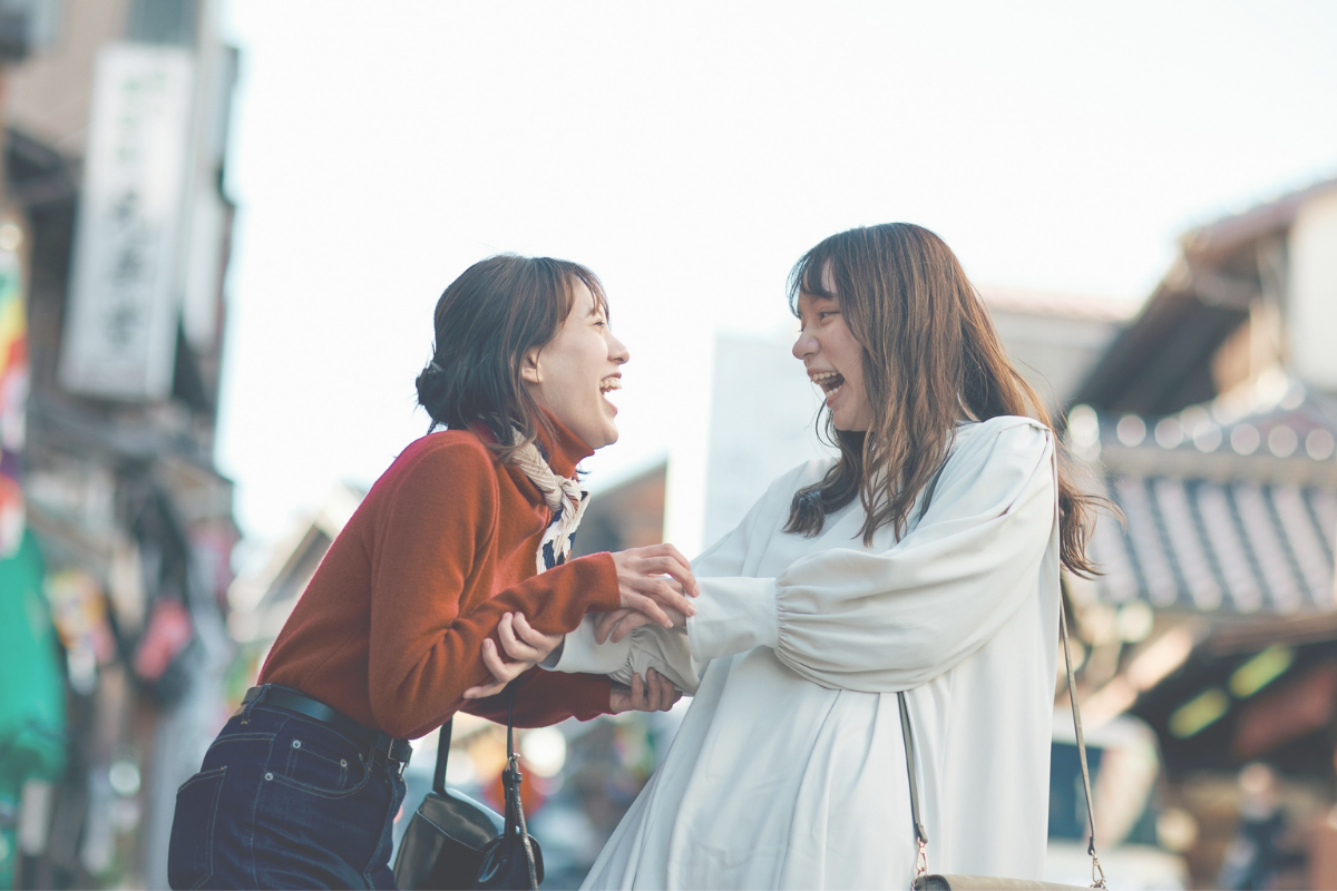 Two women smiling and talking together outdoors