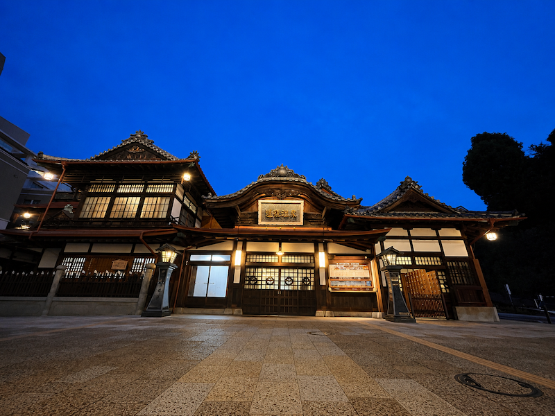 Dogo Onsen Honkan illuminated in the evening